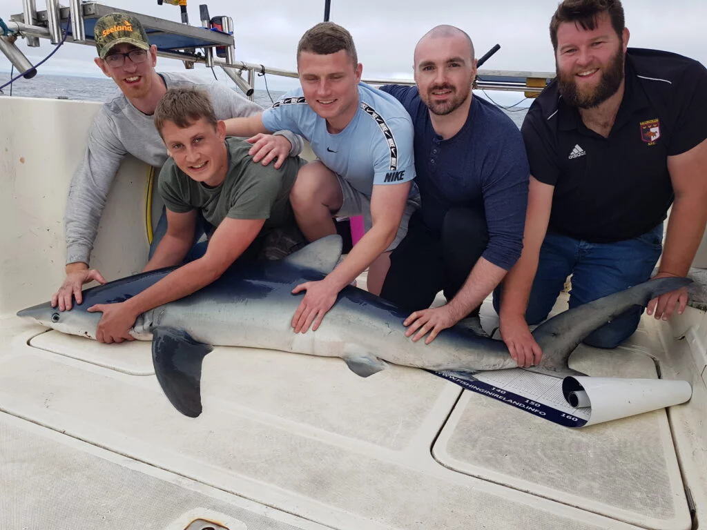 Blue Shark being held on Silver Dawn on a fishing charter
